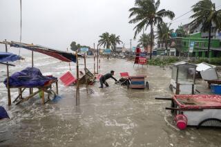 Un hombre intenta rescatar un carruaje y otras cosas en medio de una inundación en la playa Kuakata, en la costa de la Bahía de Bengala, debido a la aproximación del ciclón Remai, el domingo 26 de mayo de 2024, en Barisal, Bangladesh. (AP Foto/Abdul Goni)