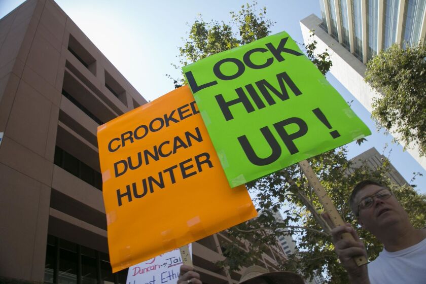 A protester who didn't want to give his name held a sign outside of the Federal Courthouse where 50th congressional district representative Duncan D. Hunter was arraigned in in San Diego on charges that he and his wife Margaret Hunter misused $250,000 in campaign contributions.