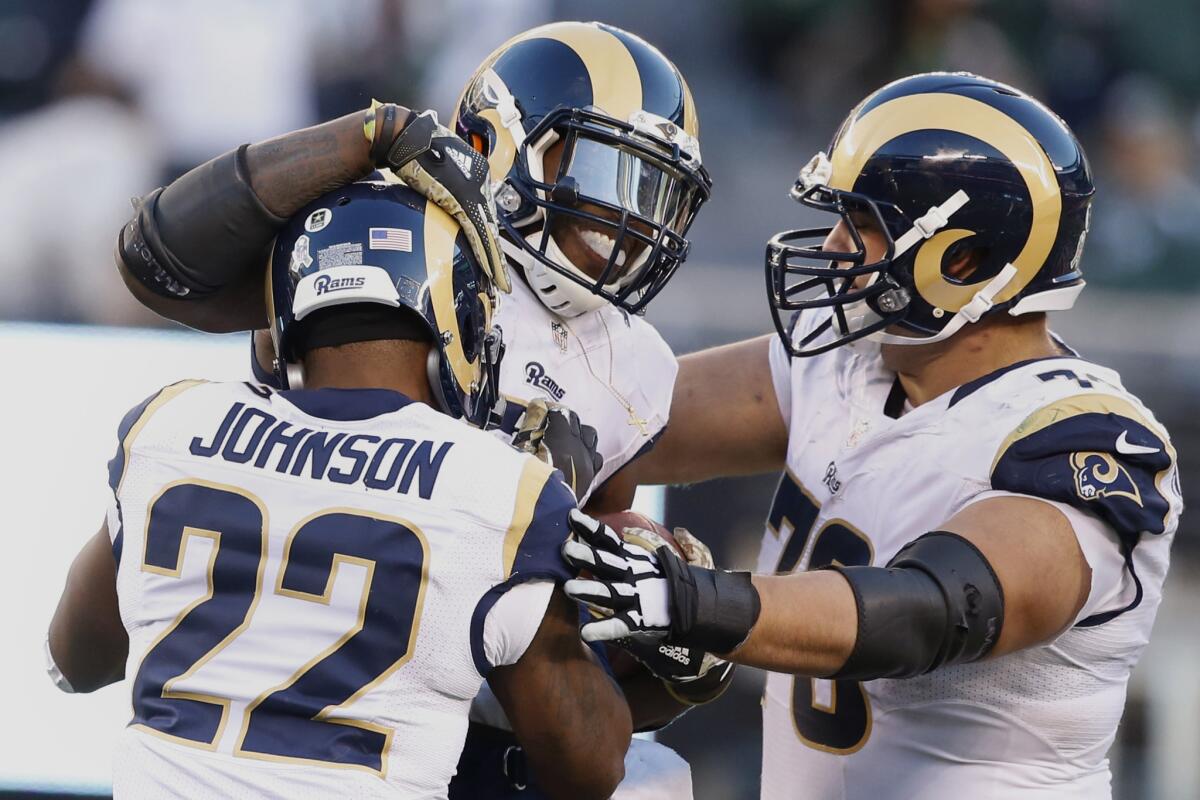 Rams linebacker Alec Ogletree celebrates with teammates Trumaine Johnson and Rob Havenstein, right, after intercepting a pass from Jets quarterback Bryce Petty late in the fourth quarter.