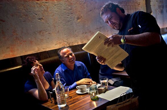 Chef David Lefevre discusses the menu with dinner guests Moyna Giddings and David Simon.