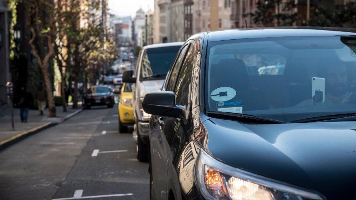 An Uber driver makes his down a street in San Francisco.