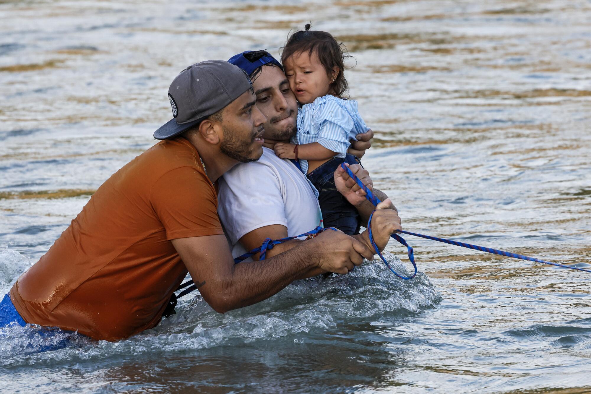 Olga Pacheco, 1, of Mexico is carried across the Rio Grande.