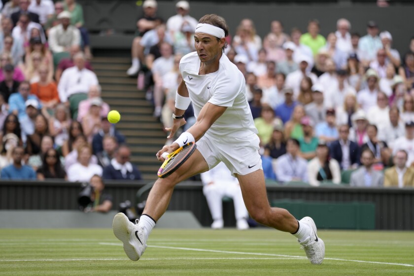 El español Rafael Nadal regresa un tiro de Taylor Fritz en partido de Wimbledon, en Londres, el miércoles 6 de julio de 2022.