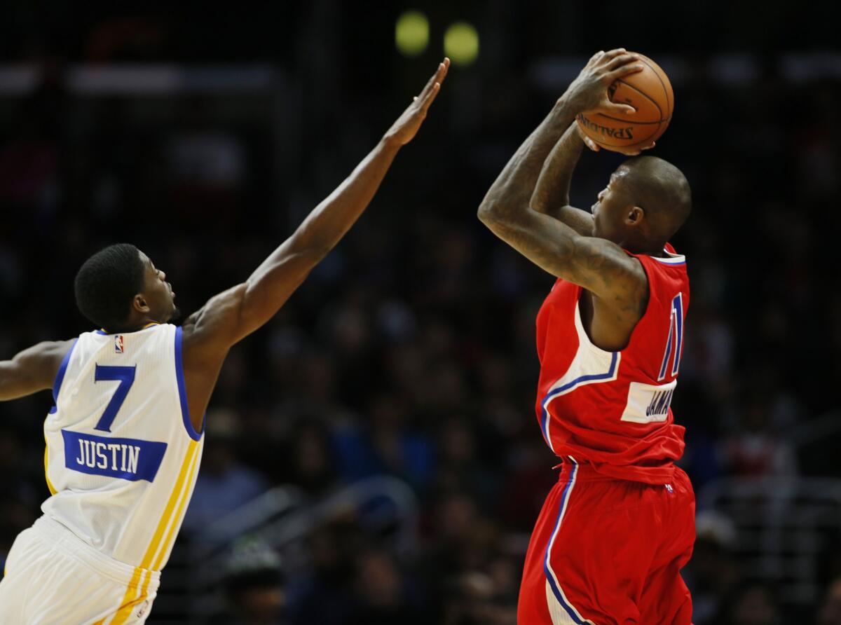 Clippers guard Jamal Crawford's shot is challenged by Warriors guard Justin Holiday during a Dec. 25 game at Staples Center.