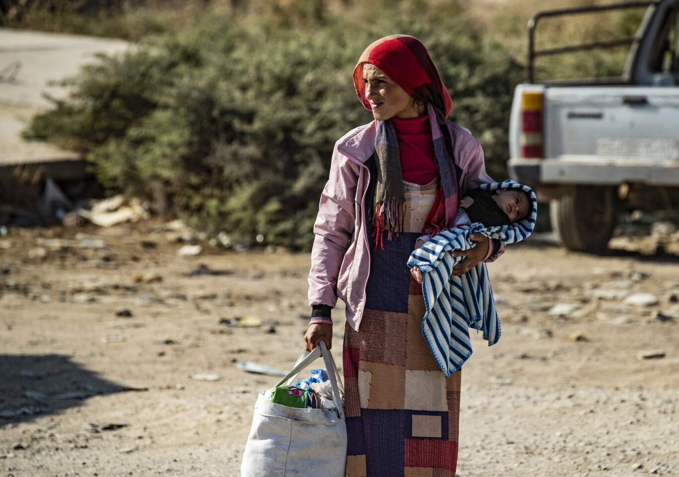 Syrian woman fleeing the battle zone between Turkey-led forces and Kurdish fighters