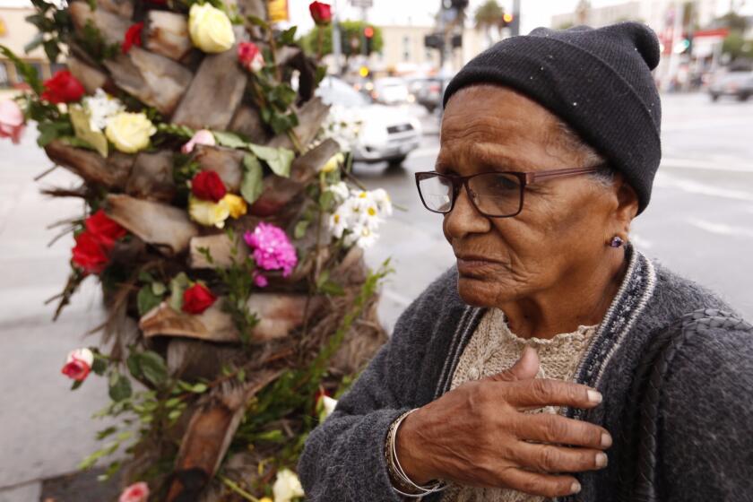 Rosa Maria Cabello crosses her heart giving a blessing at a growing memorial at the corner of Vermont Avenue and Olympic Boulevard for the victims of the tour bus crash that killed 13 people and injured 31 others.