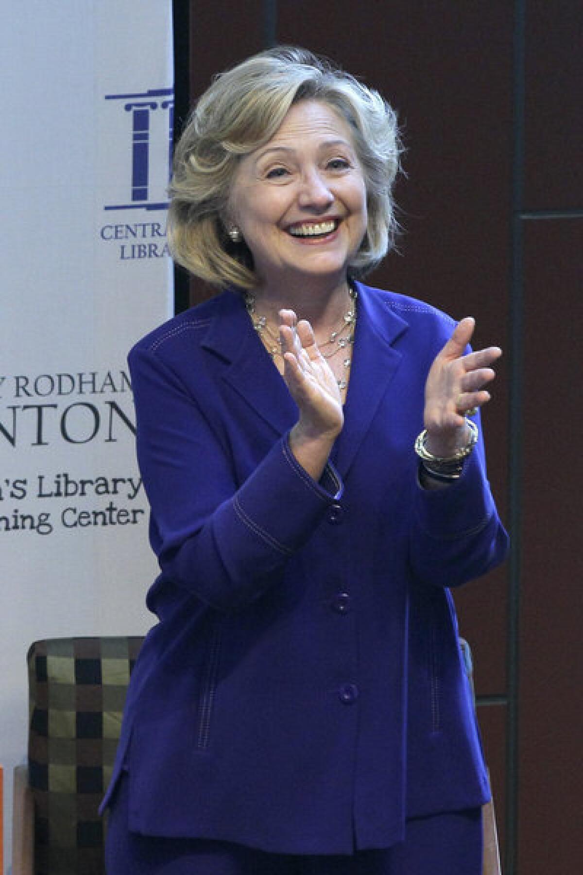 Former Secretary of State Hillary Rodham Clinton applauds at a ceremony naming a children's library in Little Rock, Ark. in her honor.