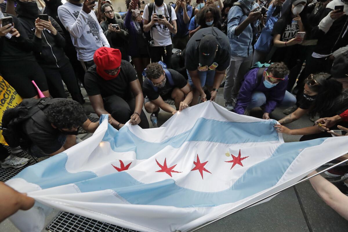 Protesters burn a Chicago flag during a demonstration over the death of George Floyd in Chicago on Saturday.