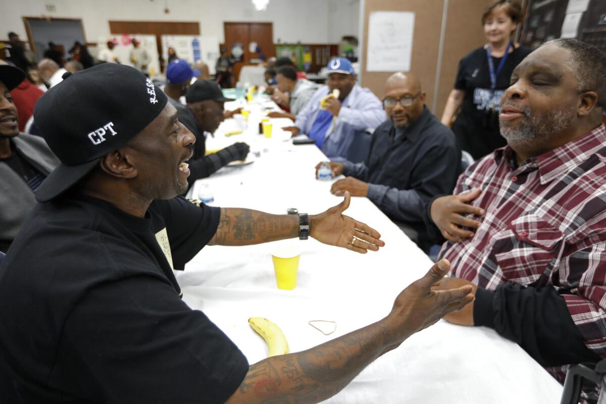 Frederick "Gangster" Staves from the Santana Blocc Crips, left, makes a point with Donal "Donwon" Holloway from the Fruit Town Pirus, at a peace summit. (Genaro Molina / Los Angeles Times)