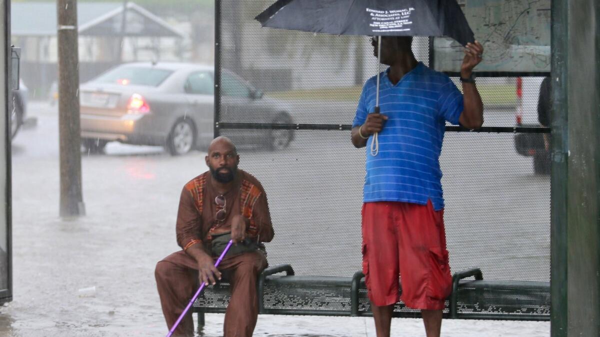 Residents take shelter along a flooded street in New Orleans.
