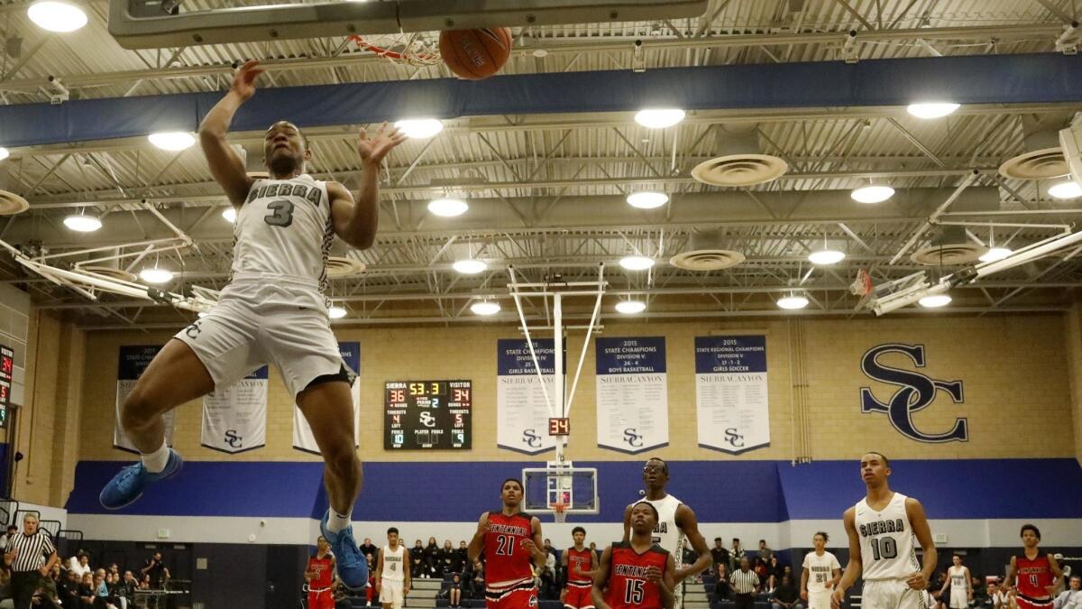 Sierra Canyon's Cassius Stanley dunks a ball as his teammates and Centennial players look on play at Sierra Canyon gym in Chatsworth on Tuesday.