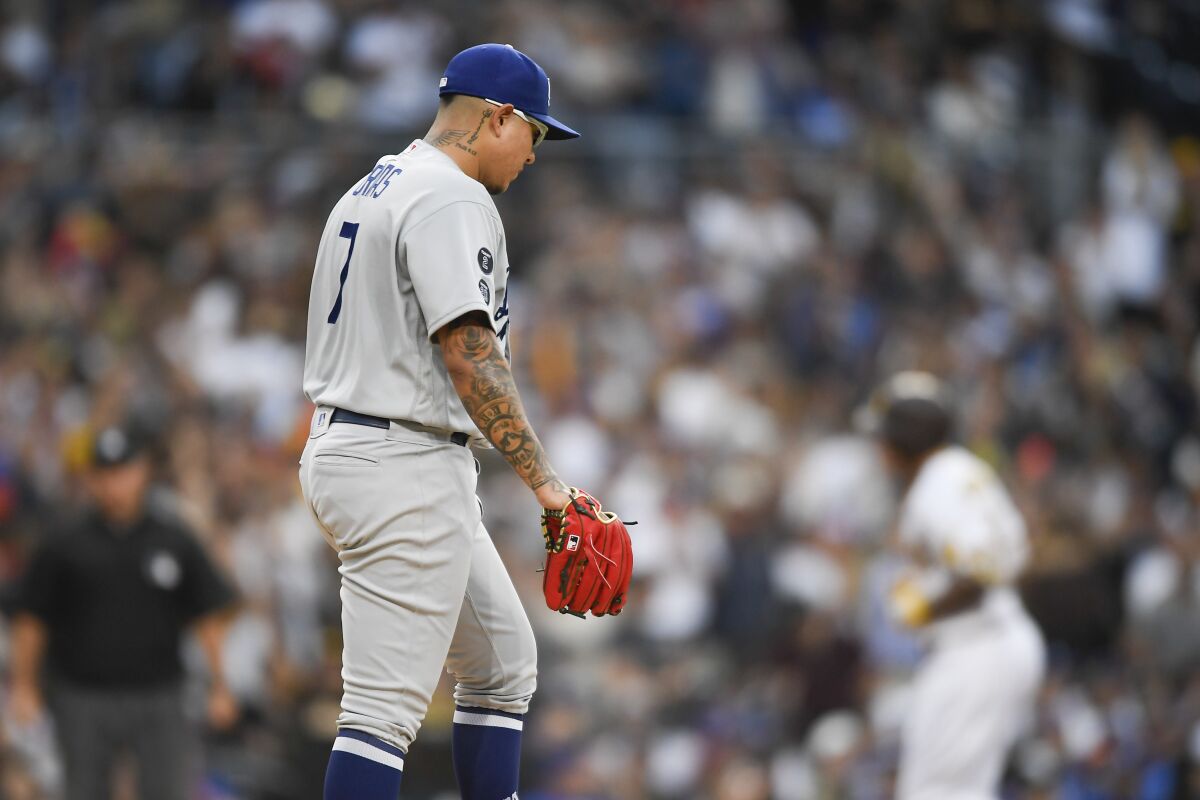 Dodgers pitcher Julio Urias looks down as San Diego Padres' Manny Machado rounds the bases.