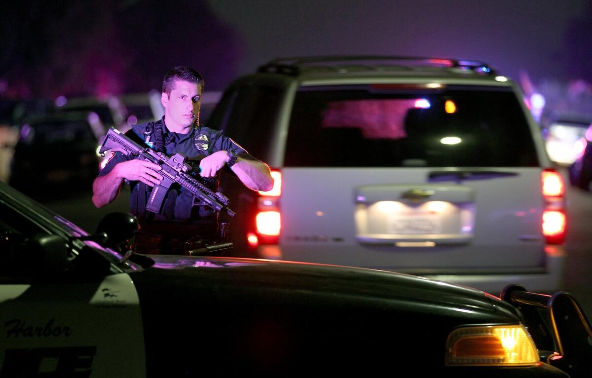 A San Diego Harbor police officer helps secure the scene near where two police officers were shot.