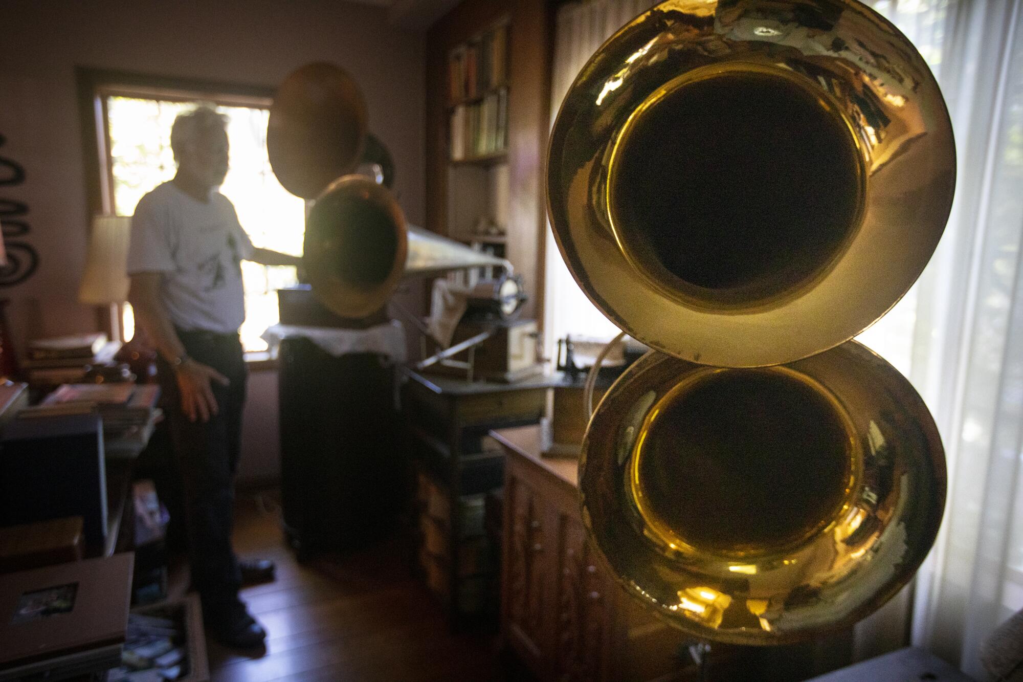 Collector John Levin with some of the machines in his collection of cylinder players.