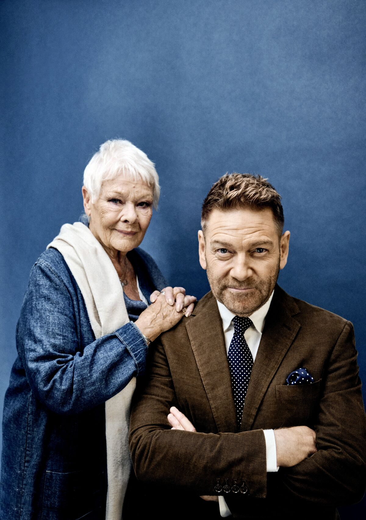 Judi Dench leans in with her hands on Kenneth Branagh's shoulders.