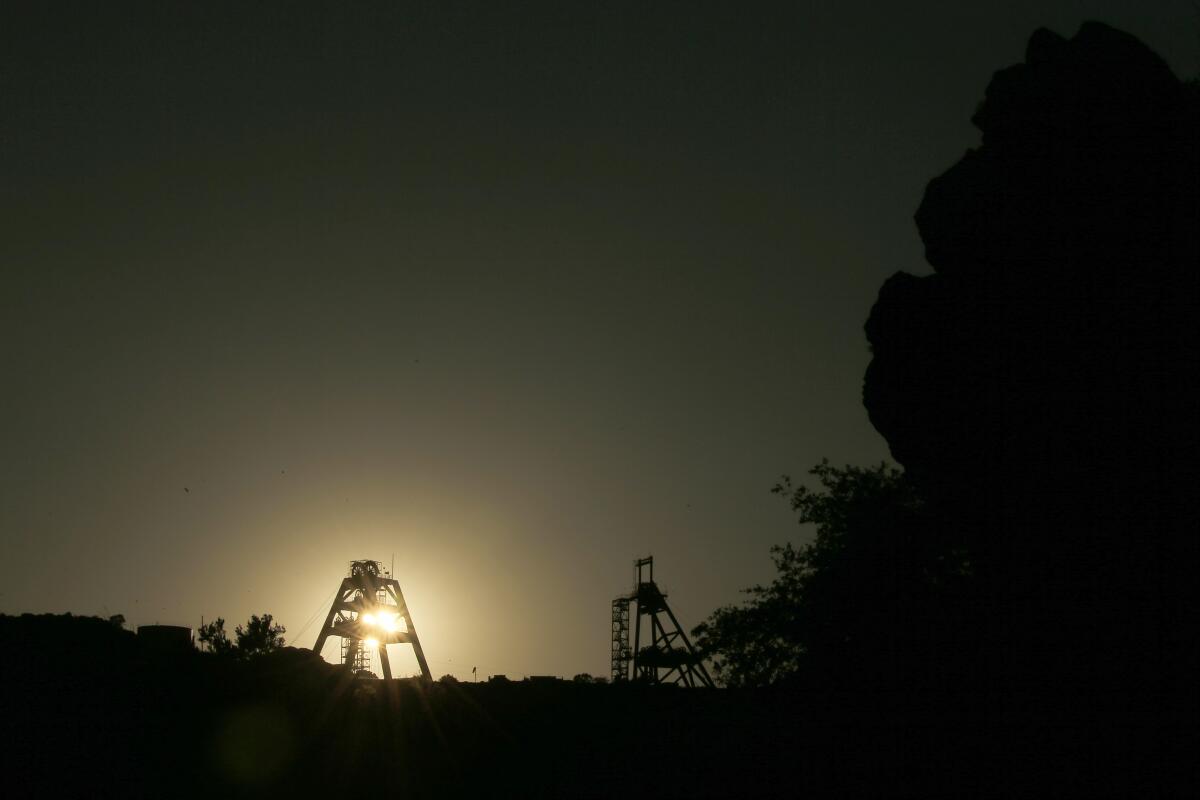 Mine shaft infrastructure is silhouetted against the setting sun at Oak Flat