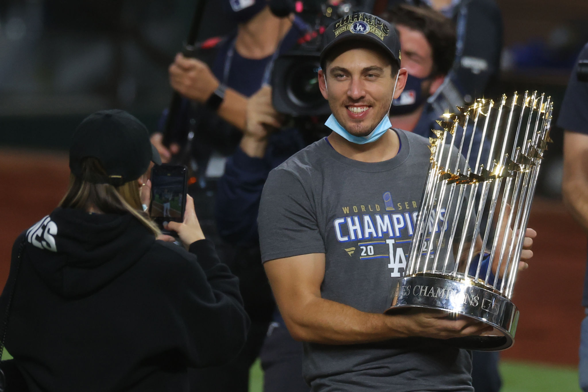 Catcher Austin Barnes celebrates with the Commissioner's Trophy after the Dodgers' World Series win.
