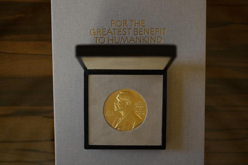FILE - The 2021 Nobel Prize for Literature medal presented to Abdulrazak Gurnah, a Tanzanian-born novelist and emeritus professor who lives in the UK, is displayed before a ceremony to present to him at the Swedish Ambassador's Residence in London, Monday, Dec. 6, 2021. The start of October is when the Nobel committees get together in Stockholm and Oslo to announce the winners of the yearly awards. (AP Photo/Matt Dunham, File)