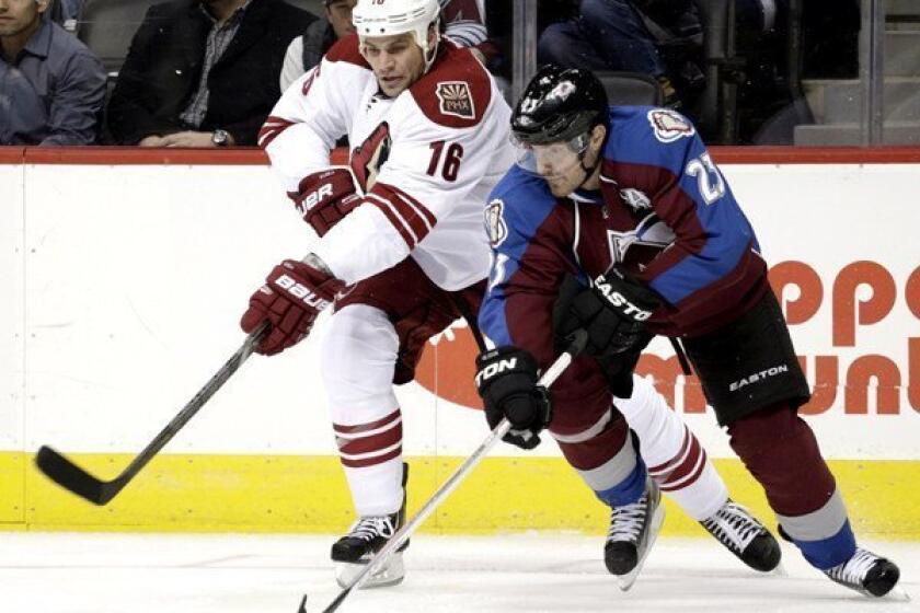 Coyotes defenseman Rusty Klesla fights for possession of the puck against Avalanche right wing Milan Hejduk during the second period of a game last month.