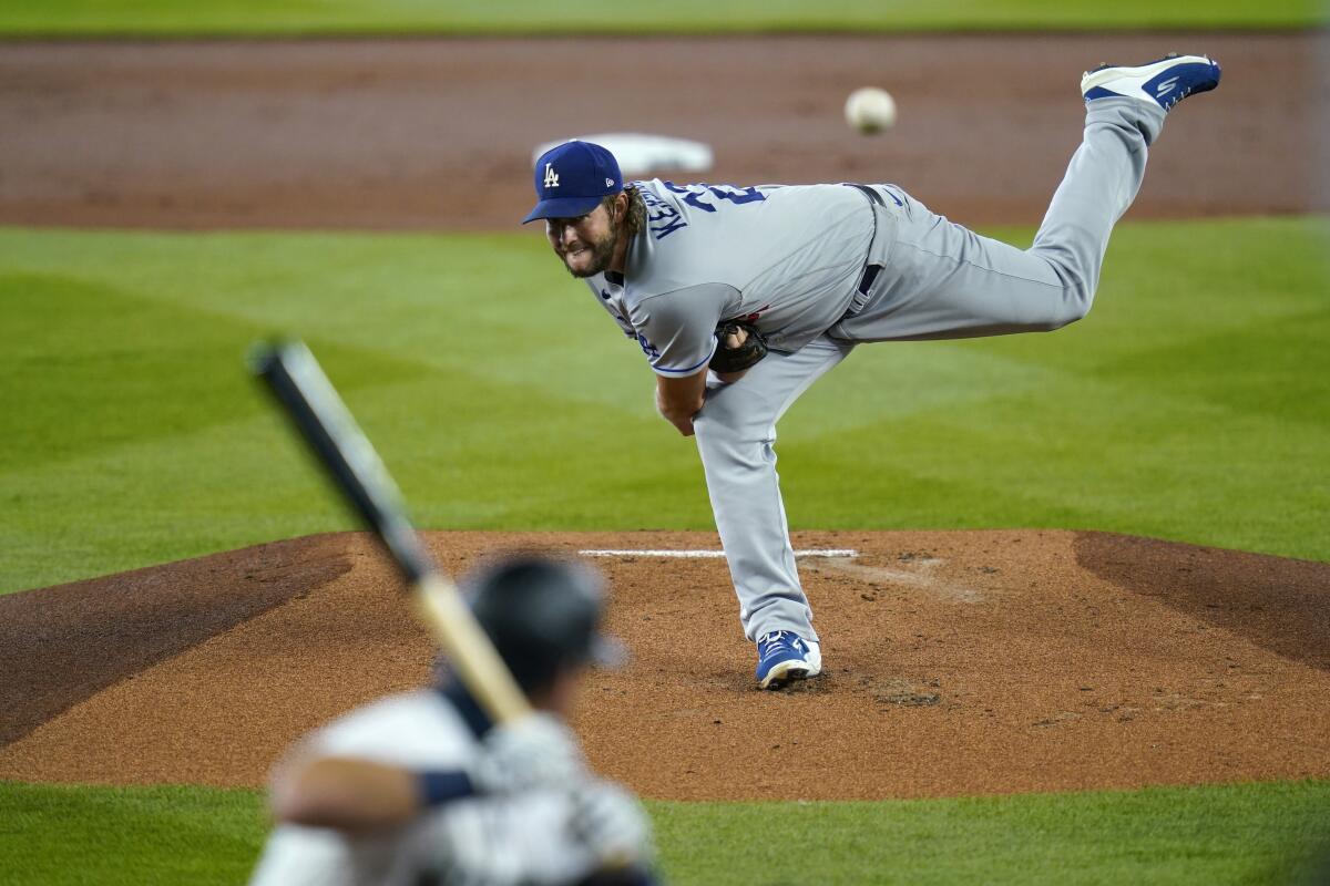 Los Angeles Dodgers starting pitcher Clayton Kershaw, top, throws against Seattle Mariners' Dylan Moore.