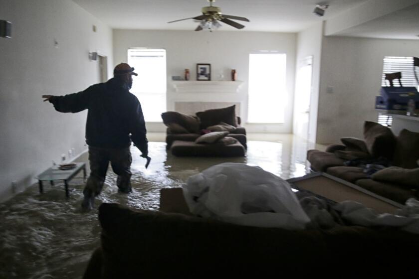 BENN COUNTY, TEXAS, MONDAY, AUGUST 28, 2017 - Jan Tullos, 32, searches an empty home for an injured woman who was reportedly stranded inside her Twin Oaks Village in Clodine. The home was empty. Tullos and dozens of other volunteers from greater Texas, spent the day ferrying people in boats to dry land. (Robert Gauthier/Los Angeles Times)