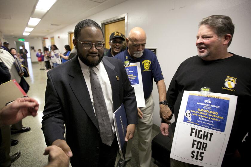 Assemblyman Sebastian Ridley-Thomas is greeted by supporters of a measure to raise the state's minimum wage.