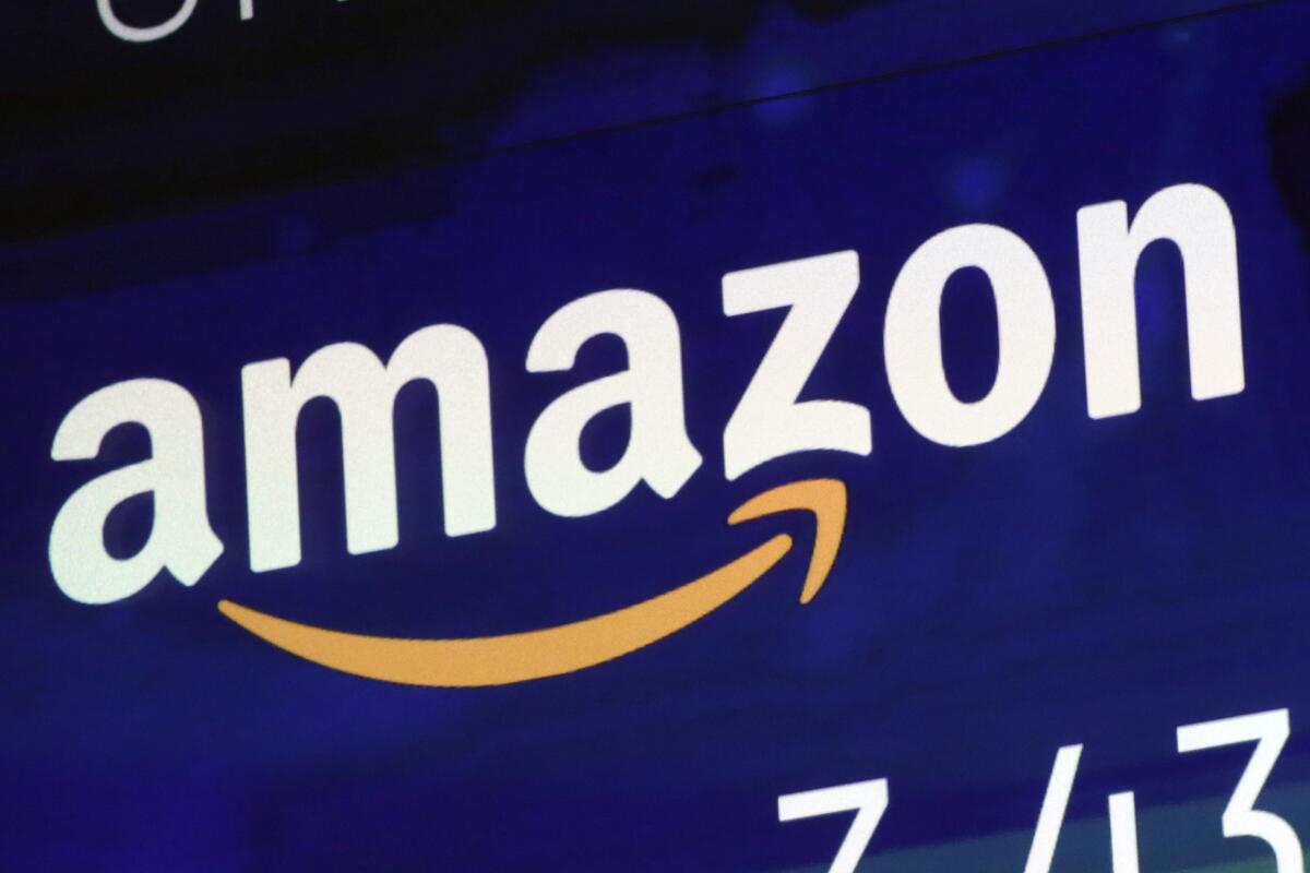 FILE - A logo for Amazon is displayed on a screen at the Nasdaq MarketSite, July 27, 2018. A fire broke out late Wednesday, Oct. 5, 2022, evening at an Amazon facility in upstate New York that’s voting in a union election next week. In a statement, an Amazon spokesperson called the incident a “small fire,” and said it was “contained to a compactor that’s located just outside the doors of a loading dock.” (AP Photo/Richard Drew, File)