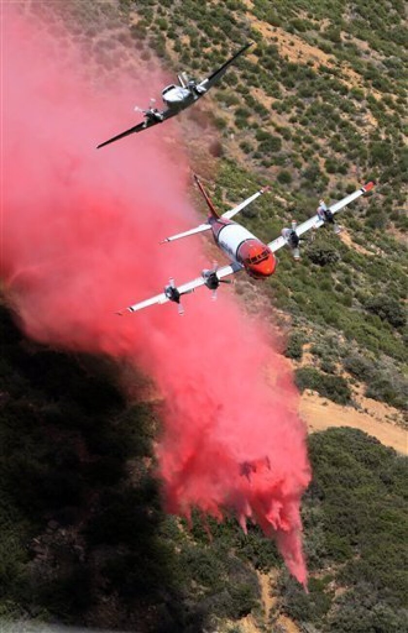 An aerial tanker, below, and its lead plane pull up after the tanker made a drop on an unburned area as efforts to fight the Jesusita fire continue in the mountains above Santa Barbara, Calif., Friday, May 8, 2009. (AP Photo/Reed Saxon)