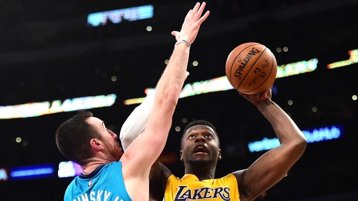 Julius Randle, right, goes for two of his 23 points against Charlotte's Frank Kaminsky III on Feb. 28 at Staples Center.