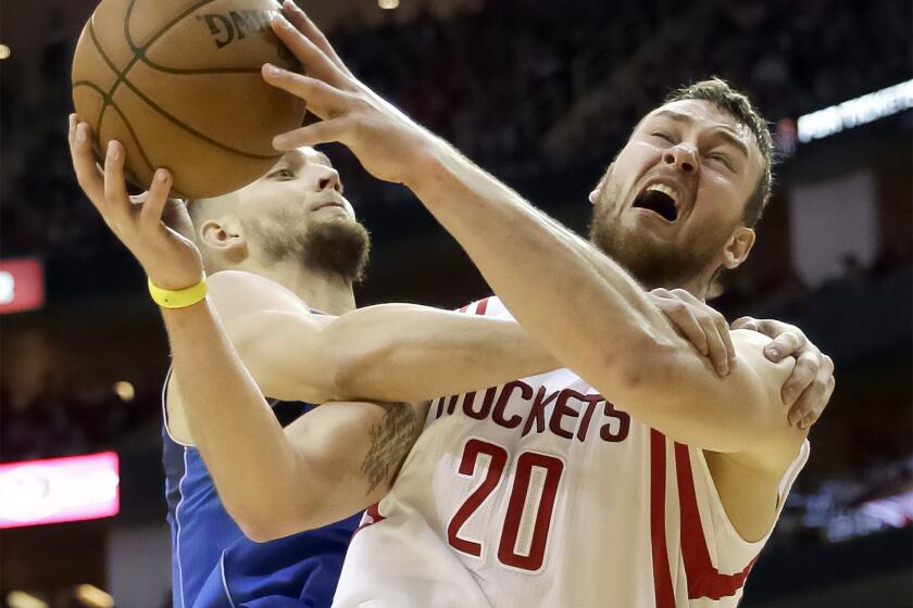 Rockets forward Donatas Motiejunas (20) is fouled by Mavericks forward Chandler Parsons during the fourth quarter.