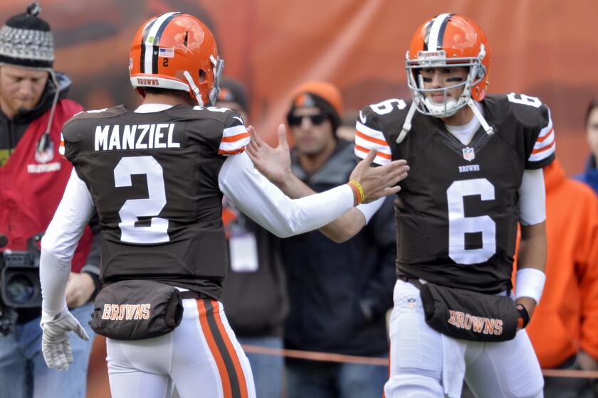 Cleveland Browns starting quarterback Brian Hoyer, right, greets backup Johnny Manziel on the sideline before a Nov. 2 game against the Tampa Bay Buccaneers.