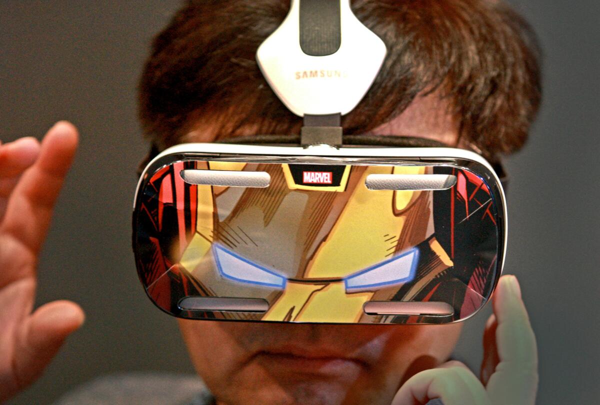 A man wears Samsung's Gear VR headset, with a Marvel's Avengers case attached to it, at the 2015 CES convention in Las Vegas on Wednesday. The entertainment industry plans to experiment with wearables such as the Gear VR in 2015.