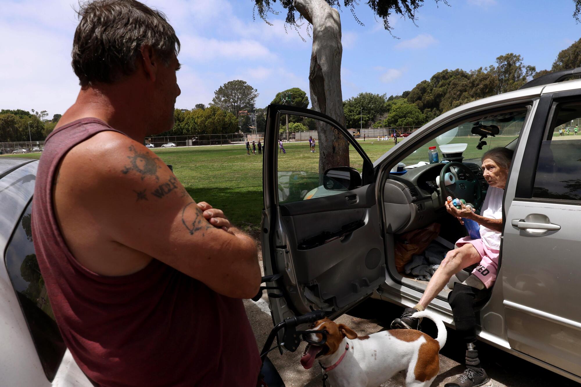 Vancie Davis talks with her son, Tom Williamson, where they both live homeless in cars parked next to each other in Venice.