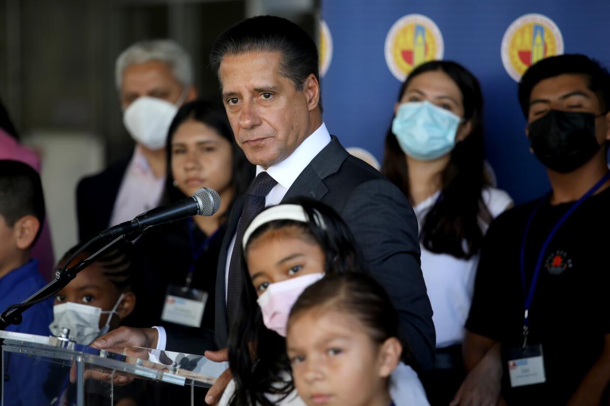 Man at microphone with people around him.