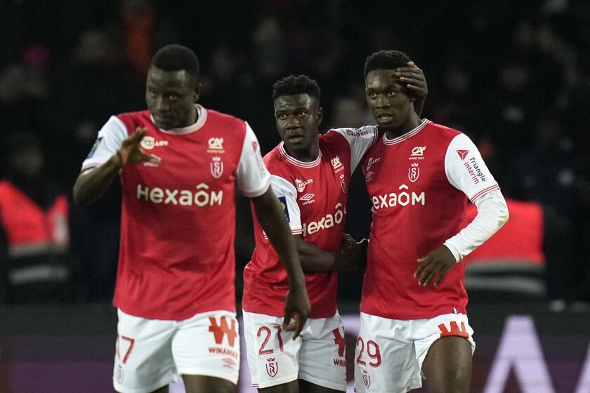Reims' Folarin Balogun, right, celebrates with teammates after scoring his side's opening goal during the French League One soccer match between Paris Saint-Germain and Reims at the Parc des Princes in Paris, Sunday, Jan. 29, 2023. (AP Photo/Thibault Camus)