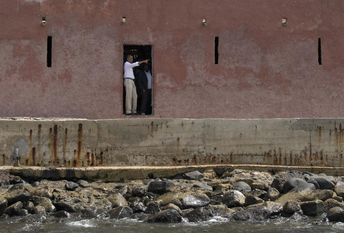 President Obama, left, talks with Slave House curator Eloi Coly as they look out to sea through the "Door of No Return" on Goree Island, in Dakar, Senegal on Thursday.