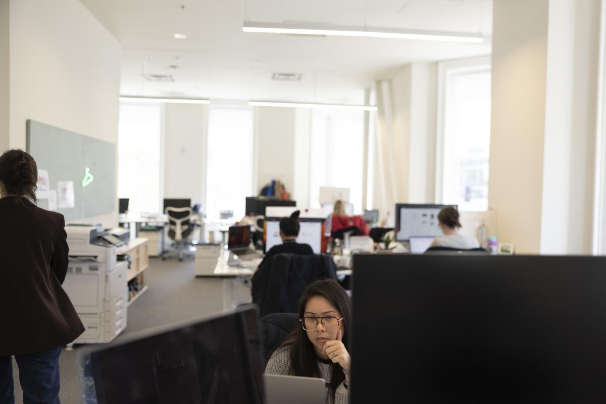 A worker sits in front of her desk.