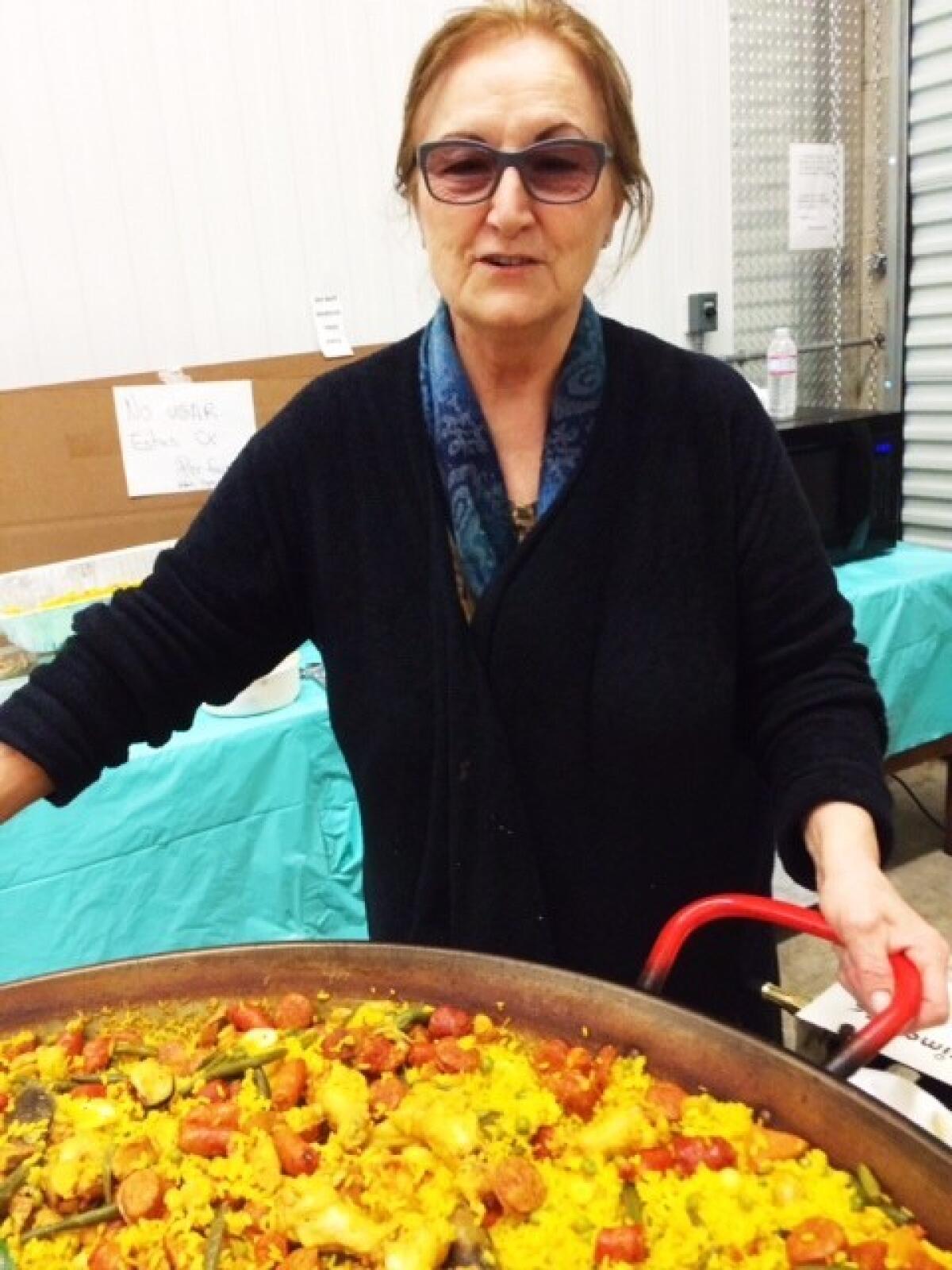 Doña Juana Faraone prepares paella in a giant pan.