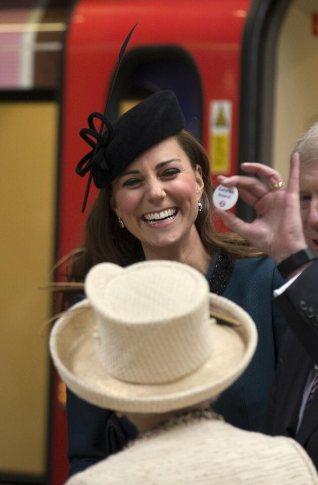 The Duchess of Cambridge happily holds a badge that says "baby on board," which signals London's Underground passengers to give their seats to pregnant patrons. The Duchess attended the 150th anniversary celebration of the subway lines.