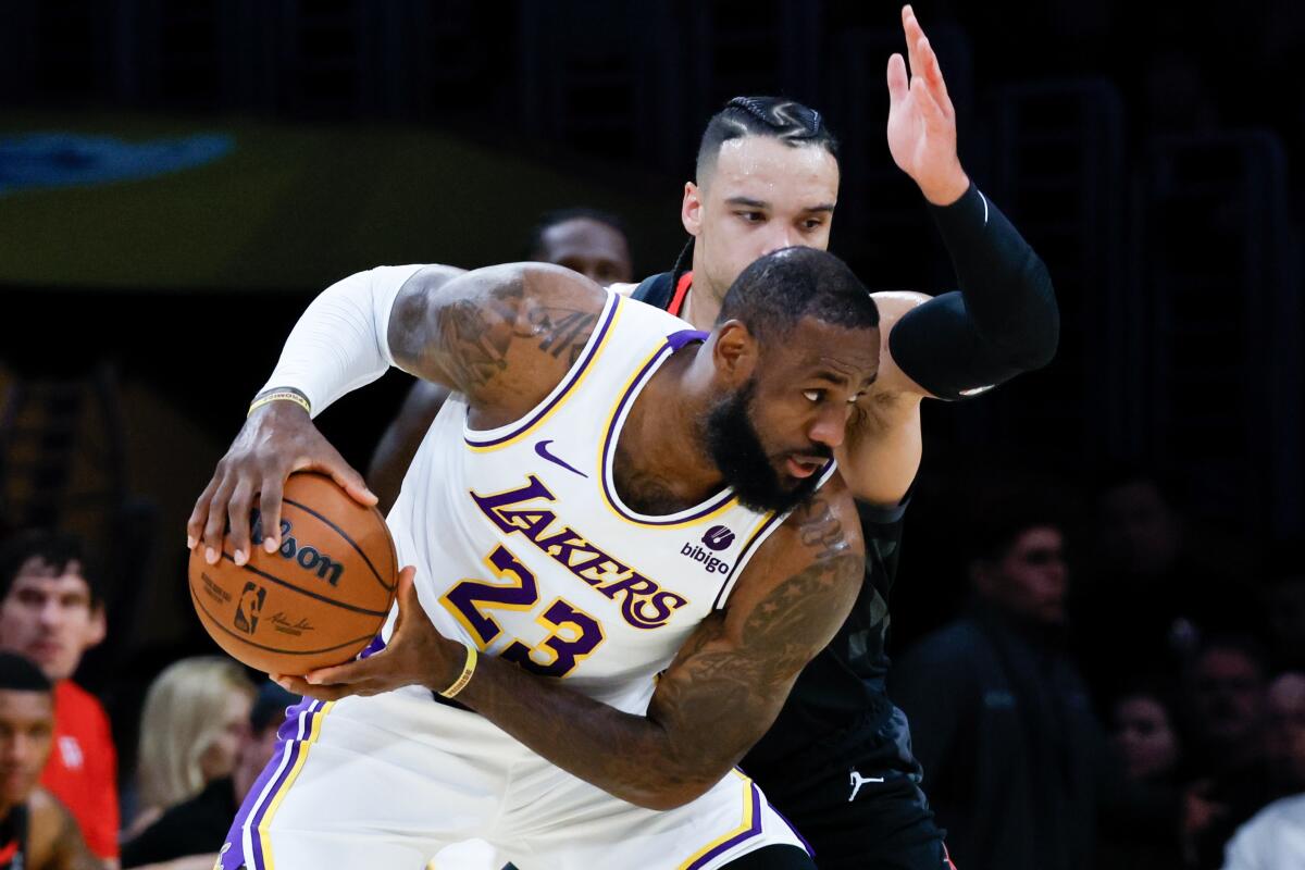 Lakers star LeBron James controls the ball in front of Houston Rockets forward Dillon Brooks at Crypto.com Arena.