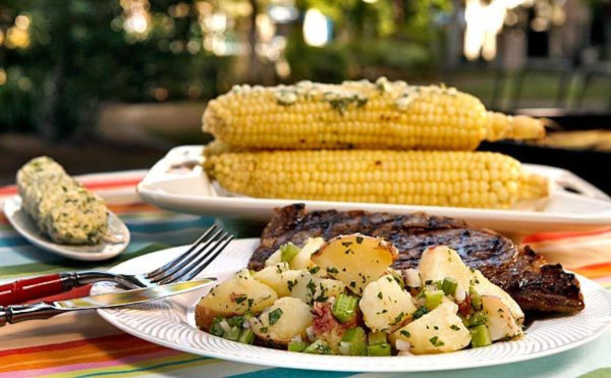 Steak, potato salad with celery and roasted corn.