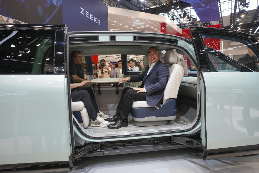 Visitors sit inside a Zeekr Mix car during the China Auto Show in Beijing, China, Friday, April 26, 2024. China's vision of the future of the automobile electrified and digitally connected is on display at the ongoing Beijing auto show. (AP Photo/Tatan Syuflana)