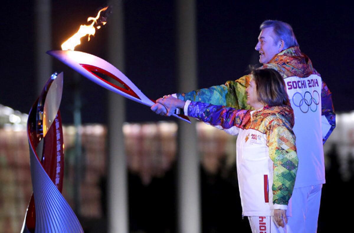 Russia's torchbearers Irina Rodnina and Vladislav Tretyak prepare to light the Olympic cauldron at the opening ceremony on Friday.