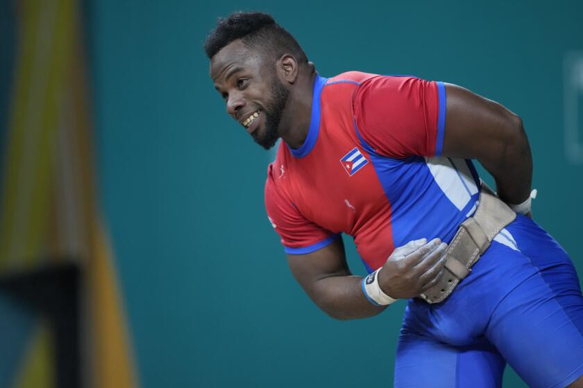 El cubano Olfides Sáez hace un gesto tras levantar una pesa en la categoría de 89 kilogramos de los Juegos Panamericanos en Santiago, el domingo 22 de octubre de 2023 (AP Foto/Moisés Castillo)