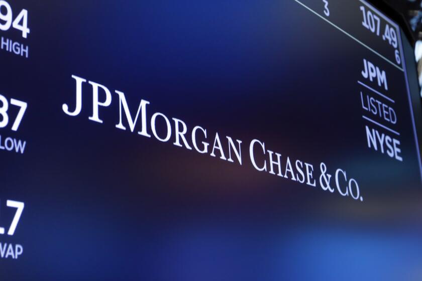 FILE - The logo for JPMorgan Chase & Co. appears above a trading post on the floor of the New York Stock Exchange in New York, Aug. 16, 2019. Chase UK, JP Morgan’s British digital bank, said Tuesday, Sept. 26, 2023, that it will bar customers from making cryptocurrency transactions starting next month — citing an uptick in scams and fraud. (AP Photo/Richard Drew, File)