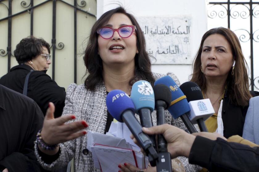 Chaima Issa, a leading figure in the coalition of parties opposed to President Kais Saied, speaks outside of a military court in Tunis, Tunisia on Tuesday, Dec. 12, 2023. Issa faces a lengthy prison term as one of the country's many activists now charged with undermining state security. (AP Photo/Hassene Dridi)