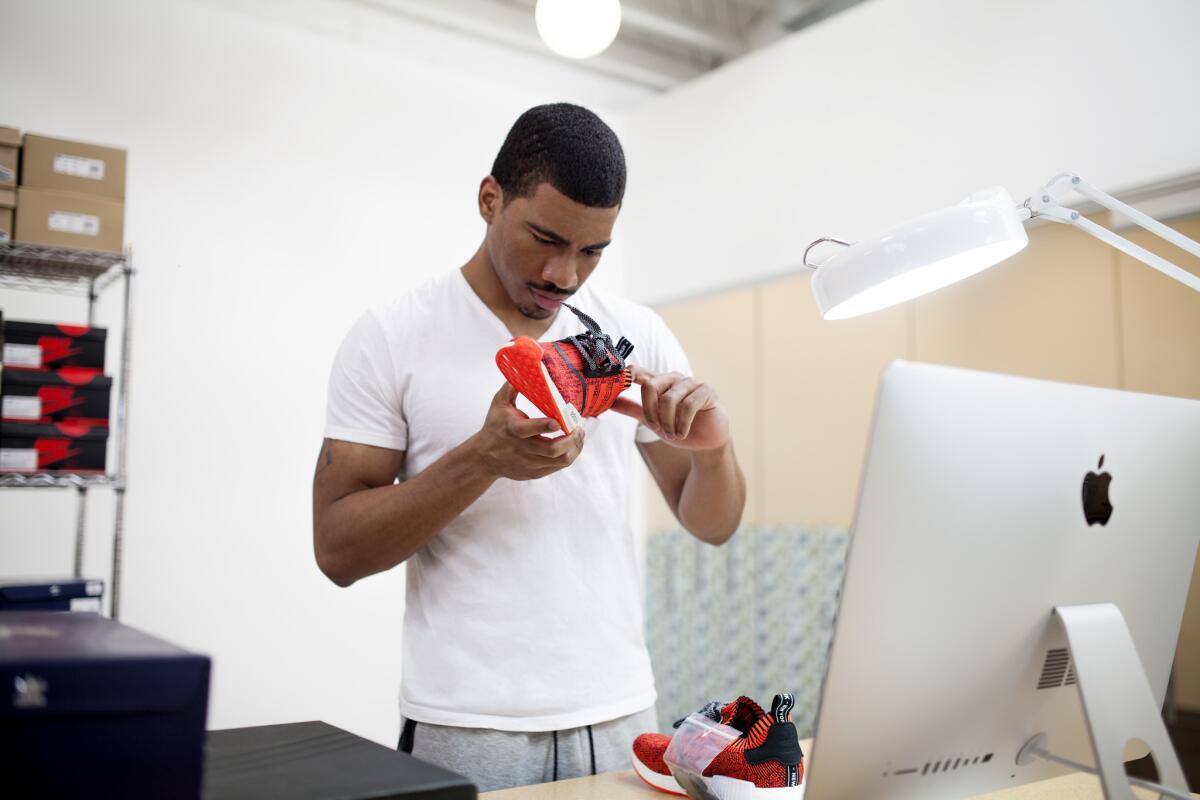 A GOAT authentication specialist studies a pair of Adidas NMD "Red Apple," a pair of shoes of which only 200 exist. (GOAT)