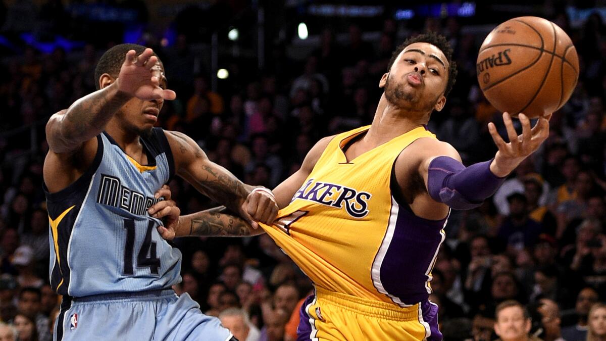 Lakers guard D'Angelo Russell tries to catch a pass while battling Grizzlies guard Xavier Munford for position during their game Tuesday.