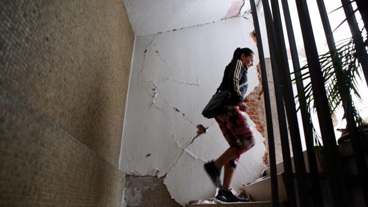 A woman climbs the stairs in an earthquake-damaged building in Condesa.