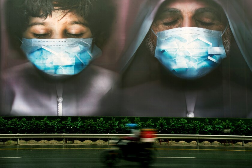 FILE - In this April 15, 2020 file photo, a billboard urges people to stay home during the coronavirus pandemic in Dubai, United Arab Emirates. Middle East economies are recovering from the coronavirus pandemic faster than anticipated, largely due to the acceleration of mass inoculation campaigns and an increase in oil prices. But the International Monetary Fund warned Sunday, April 11, 2021, that an uneven vaccine distribution would derail the region's rebound, as the prospects of rich and poor countries diverge. (AP Photo/Jon Gambrell, File)